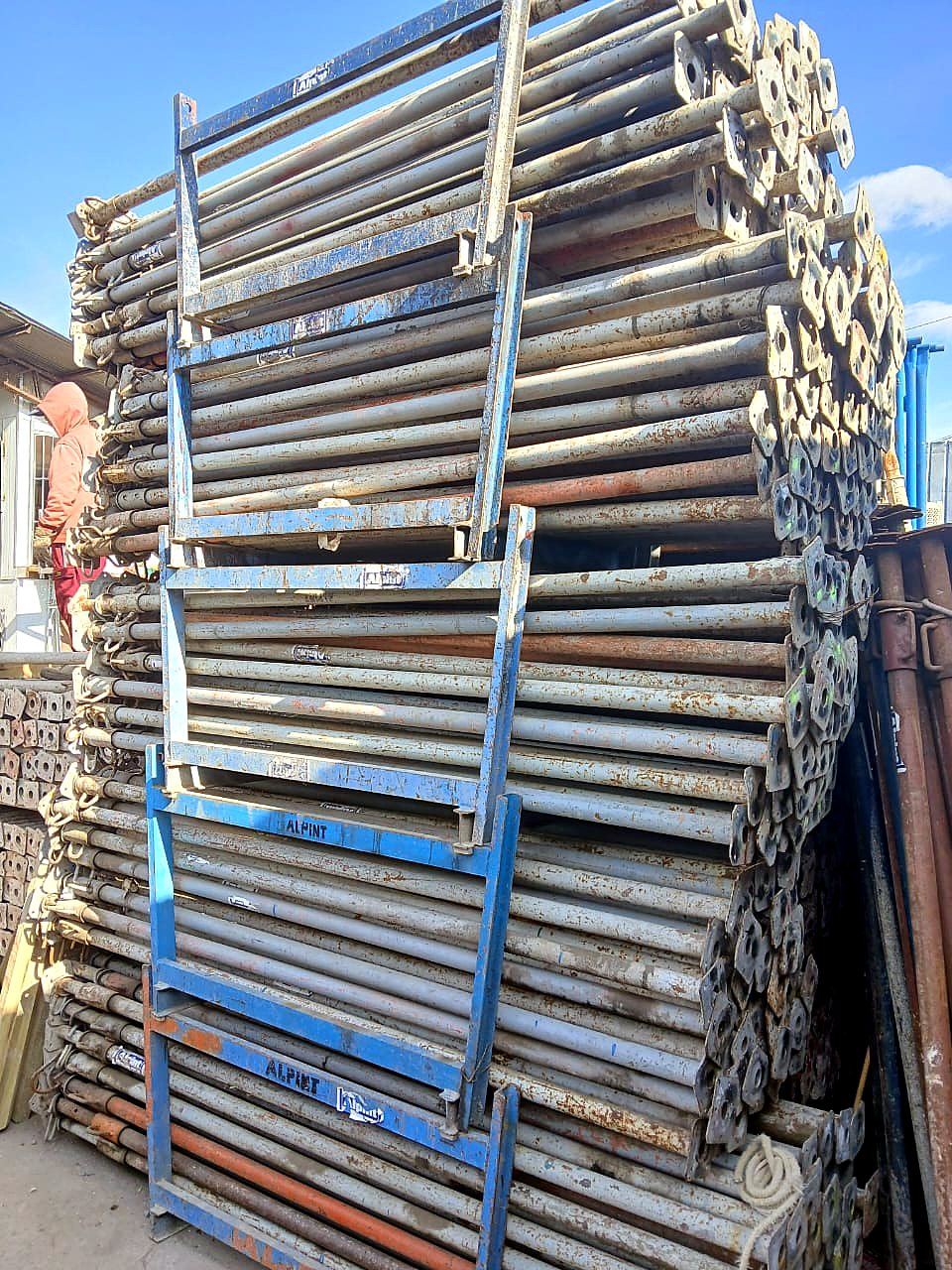 Estructuras y bases ALPINT apiladas en bodega, con marca visible en los marcos